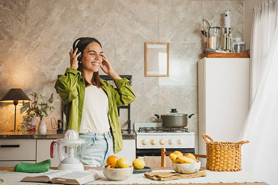 Woman in a kitchen holding a cup of tea and smiling